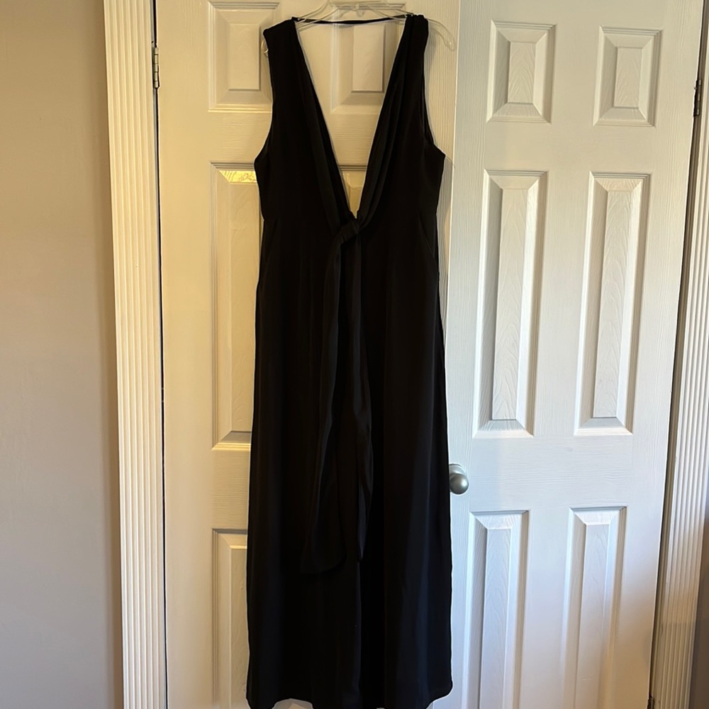 Black jumpsuit, deep v, open back, has pockets